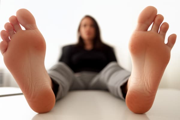 she is sitting, and her soles are up close to the camera