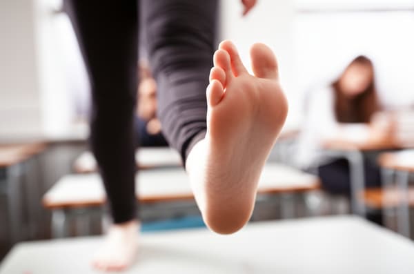 Brown short hair, size 39 eu feet, barefoot on a desk, gray pants
